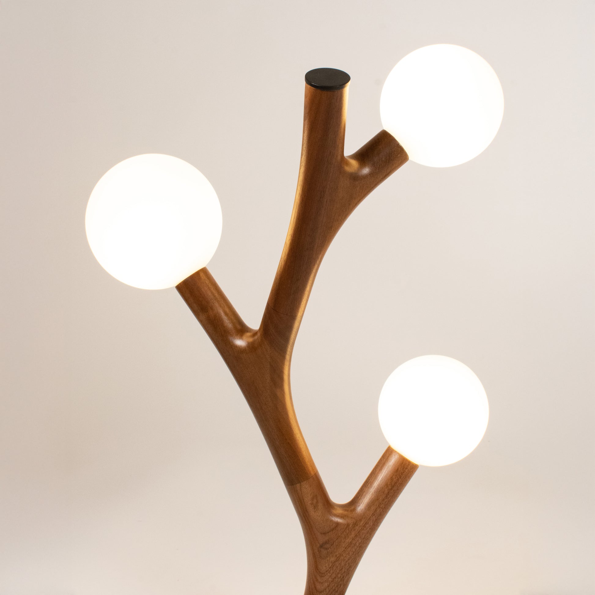 Wooden lamp with three spherical lights on a beige background