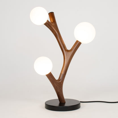 Wooden table lamp with three spherical lights on a white background