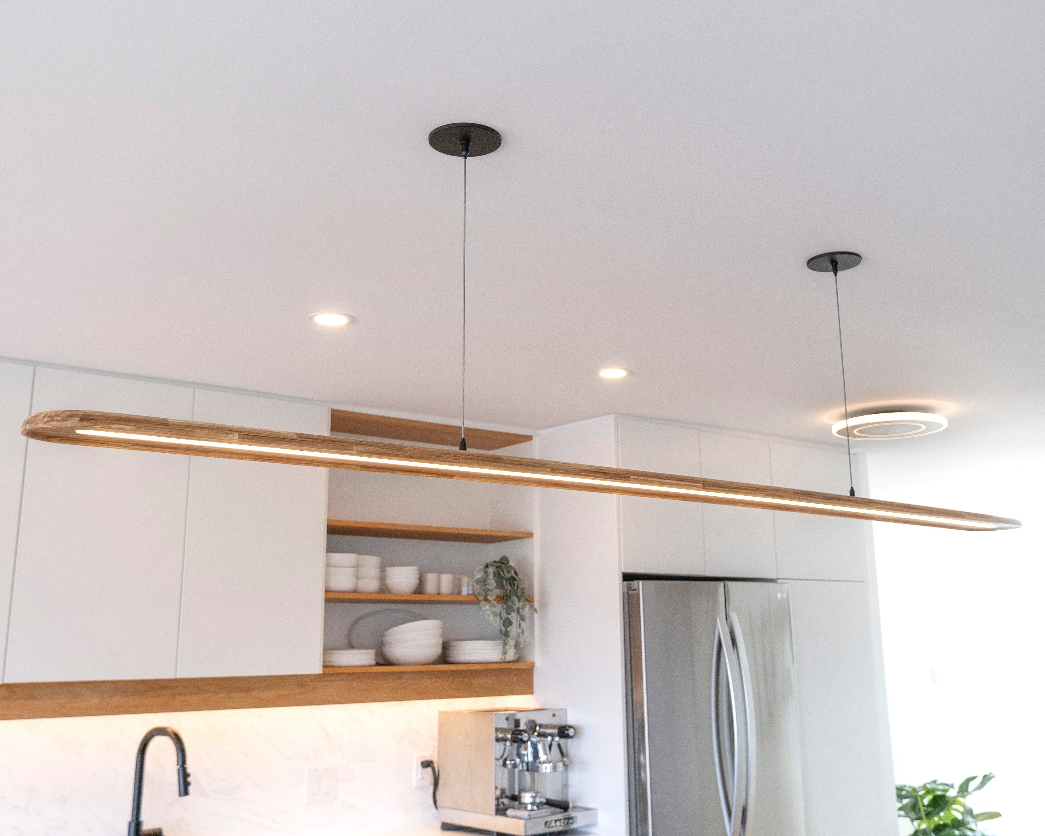 Nimbus solid hardwood linear pendant light hanging over kitchen island